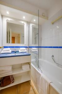 芒通两岸公园皮埃尔假日公寓酒店的一间带水槽、浴缸和镜子的浴室