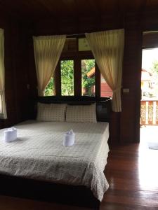 象岛Phet Ban Suan Hotel的一间卧室配有一张带白色床单和窗户的床。