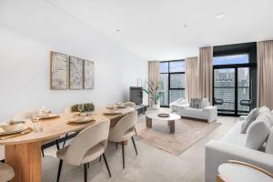 迪拜Meerak Homes - Glamorous 2 bed Apartment with Panoramic Views - Business Bay with free Wifi, Parking, Gym and Pool的客厅配有桌椅和沙发