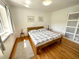 Pinsdorf乡村度假屋 - 蒙登涅的一间卧室配有一张床,铺有木地板