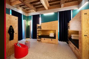 罗马JO&JOE ROMA的一间卧室设有两张双层床和一张红色椅子
