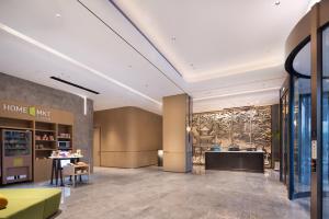 贵阳Home2 Suites by Hilton Guiyang Guanshanhu的大厅,带黄色沙发的家庭集市