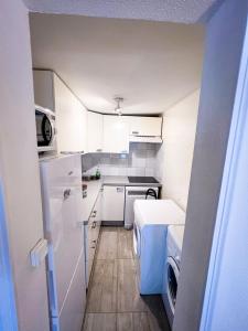 巴黎Charming two-room apartment near Montparnasse的一间小厨房,配有白色的橱柜和一台洗衣机