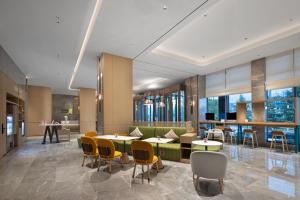 贵阳Home2 Suites by Hilton Guiyang Guanshanhu的大堂设有桌椅和窗户。