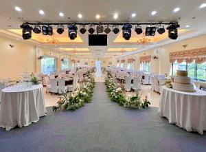 山萝Khách sạn Hoàng Sơn的宴会厅配有白色的桌子和白色的椅子