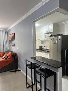 里约热内卢Suites W-Riocentro的厨房配有桌子、冰箱和床。