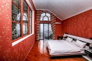 巴库PANORAMA VILLA 5 MIN. TO NIZAMI STREET的卧室设有红色的墙壁和一张带白色床单的床