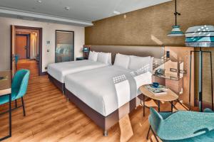 安塔利亚Doubletree By Hilton Antalya City Centre的一间卧室配有一张大床和一张桌子及椅子