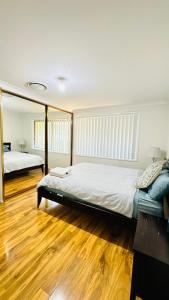 卧龙岗Quiet family Townhouse in Wollongong CBD的一间卧室设有两张床,铺有木地板