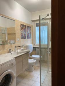 布鲁尼科Appartamento Grunwald的浴室配有卫生间、盥洗盆和洗衣机。