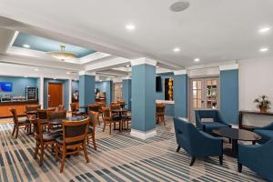维洛海滩Comfort Suites Vero Beach I-95的一间配备有桌椅的用餐室和蓝色的墙壁