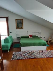 帕多瓦A casa di Rosa的一间卧室配有绿色的床和沙发
