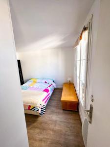巴黎Charming two-room apartment near Montparnasse的一间带床和木桌的小卧室