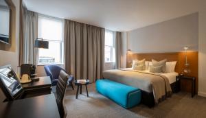 伦敦Clayton Hotel London Wall的酒店客房设有一张大床和一张书桌。