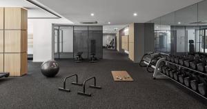 墨尔本Luxury Living, Richmond的健身房,配有一束椅子和举重器材