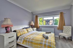 罗切斯特Finest Retreats - Royal Nights Place的卧室配有床、椅子和窗户。