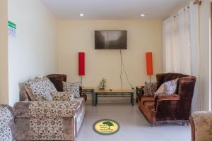 MweigaJuniper Green Gardens Resort.的客厅配有两张沙发和一台电视机