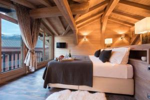 蒂涅Chalet Ambre的一间卧室设有一张床和一个大窗户