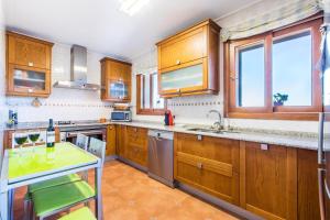 布格Buger - 3721 Mallorca的厨房配有木制橱柜和不锈钢用具