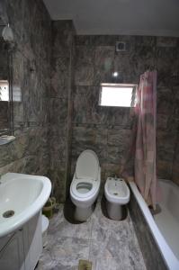 蒙特格兰德Hostel Aeropuerto Ezeiza的浴室配有盥洗盆、卫生间和浴缸。