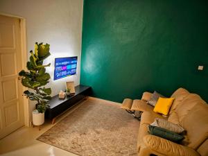巴佐Homestay Rumah Tengok Jelawat Bachok的带沙发和绿色墙壁的客厅