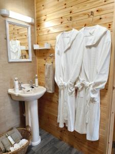 多尼戈尔Robins Rest的一间带水槽和白色浴袍的浴室
