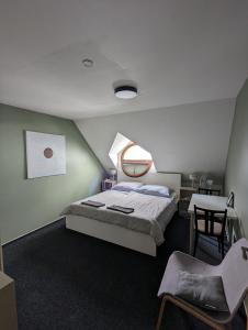 布尔诺约翰高尔特旅馆的卧室配有1张床、1张桌子和1把椅子