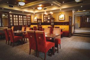 ToomeO'Neill Arms Hotel的用餐室配有桌子和红色椅子