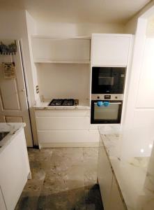 巴塞尔顿Private luxurious space的厨房配有白色橱柜和烤箱。