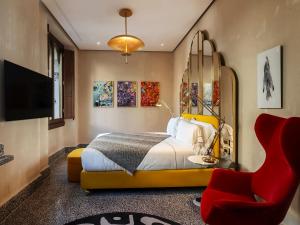 佛罗伦萨Hotel Calimala的一间卧室配有一张床和一张红色椅子