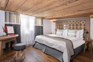 GontenAppenzeller Huus Bären的一间卧室设有一张带木制天花板的大床