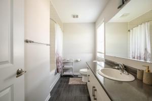 布兰普顿GLOBALSTAY Modern 3 Bedroom House in Brampton的一间带水槽、卫生间和镜子的浴室
