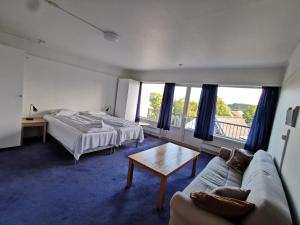 曼达尔SKAP Hostel Mandal的一间卧室配有两张床、一张沙发和一张桌子