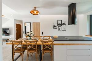 什切尔克Apartament Na Górce - Enklawa Pod Skrzycznem - Dream Apart的厨房配有木桌和椅子