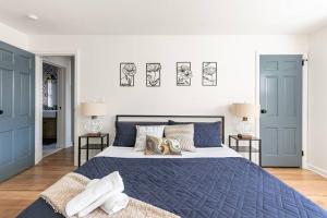 新罗谢尔Fire pit ~ Game Room ~ near NYC ~ Modern Luxury的卧室设有蓝色门和一张带枕头的床