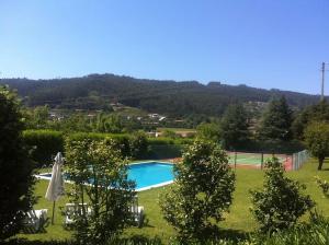 维拉诺瓦-德法马利Casa do Tanque的一个带网球场的庭院内的游泳池