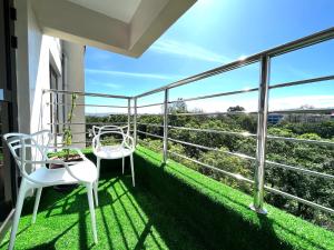 纳库鲁Midtown Executive Suites With Balcony, King Bed的阳台配有2把白色椅子,享有美景。