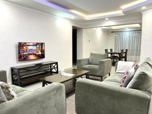 纳库鲁Midtown Executive Suites With Balcony, King Bed的带沙发、椅子和桌子的客厅