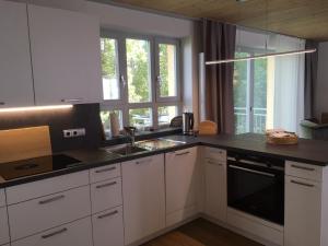 奥森富尔特Ferienhaus "Am Saarbach"的厨房配有白色橱柜和黑色台面