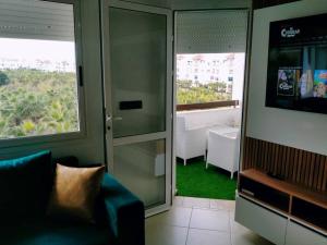 艾西拉Marina golf studio的带沙发和滑动玻璃门的客厅