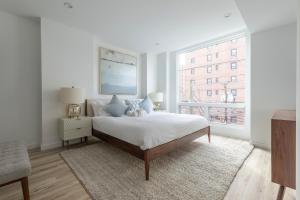霍博肯Sun-kissed 3BR Loft with Patio Minutes to NYC的白色的卧室设有床和窗户