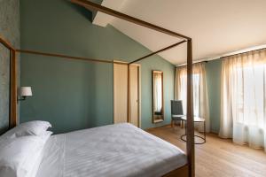 博洛尼亚波尔塔圣马莫洛酒店的一间卧室,卧室内配有一张天蓬床