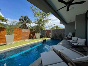 珍南海滩La Mer Luxury Villa - Private Pool Langkawi的围栏旁带躺椅的游泳池