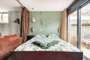 霍恩Bed & Bike Harbour Hoorn的一间卧室配有一张床、一张沙发和一个窗口
