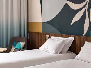 维特罗勒金色郁金香马赛机场酒店的酒店客房设有两张床和一张桌子。