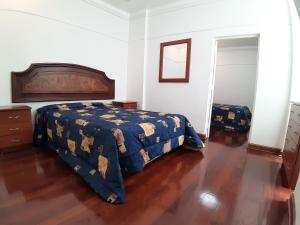利马APARTAMENTO LINDO - A 2 Cuadras de la Plaza de Armas y del Palacio de Gobierno的一间卧室配有一张床,铺有木地板