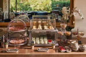 托莱多Hotel Boutique Cigarral de las Mercedes的餐桌上的自助餐,包括食物