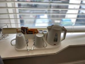 安布尔塞德The Unicorn, Ambleside的窗边的柜台上的白咖啡壶和杯子