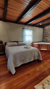 皮卡达卡费Cabana Casa Enxaimel的卧室内的一张大床,铺有木地板