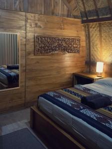 BesakihBesakih Homestay & Villa的木墙客房的两张床